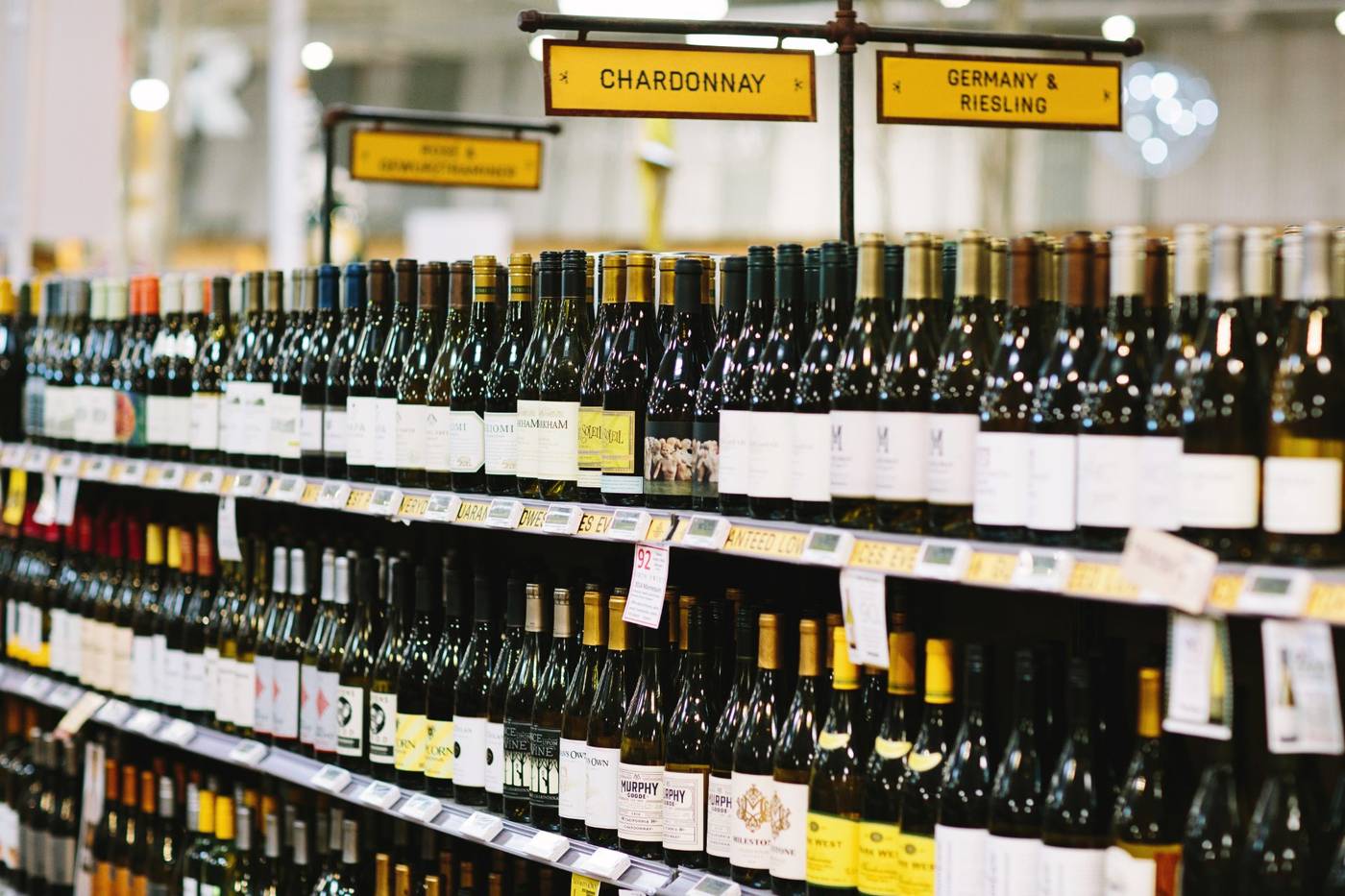 Stocked wine shelves with category signs in a real mPower customer store